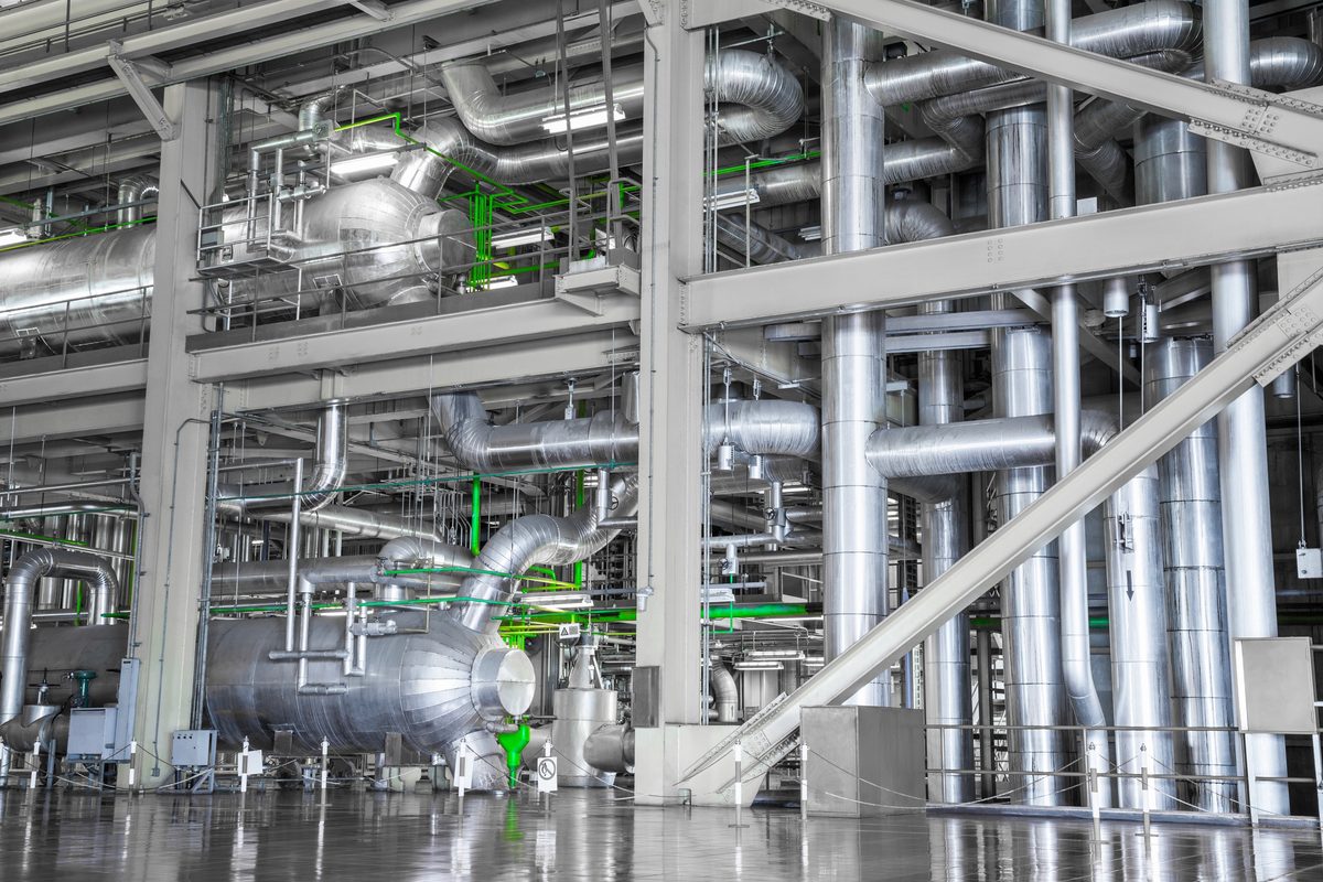 Insulated pipework, vessels and steel frames inside an industrial process plant.