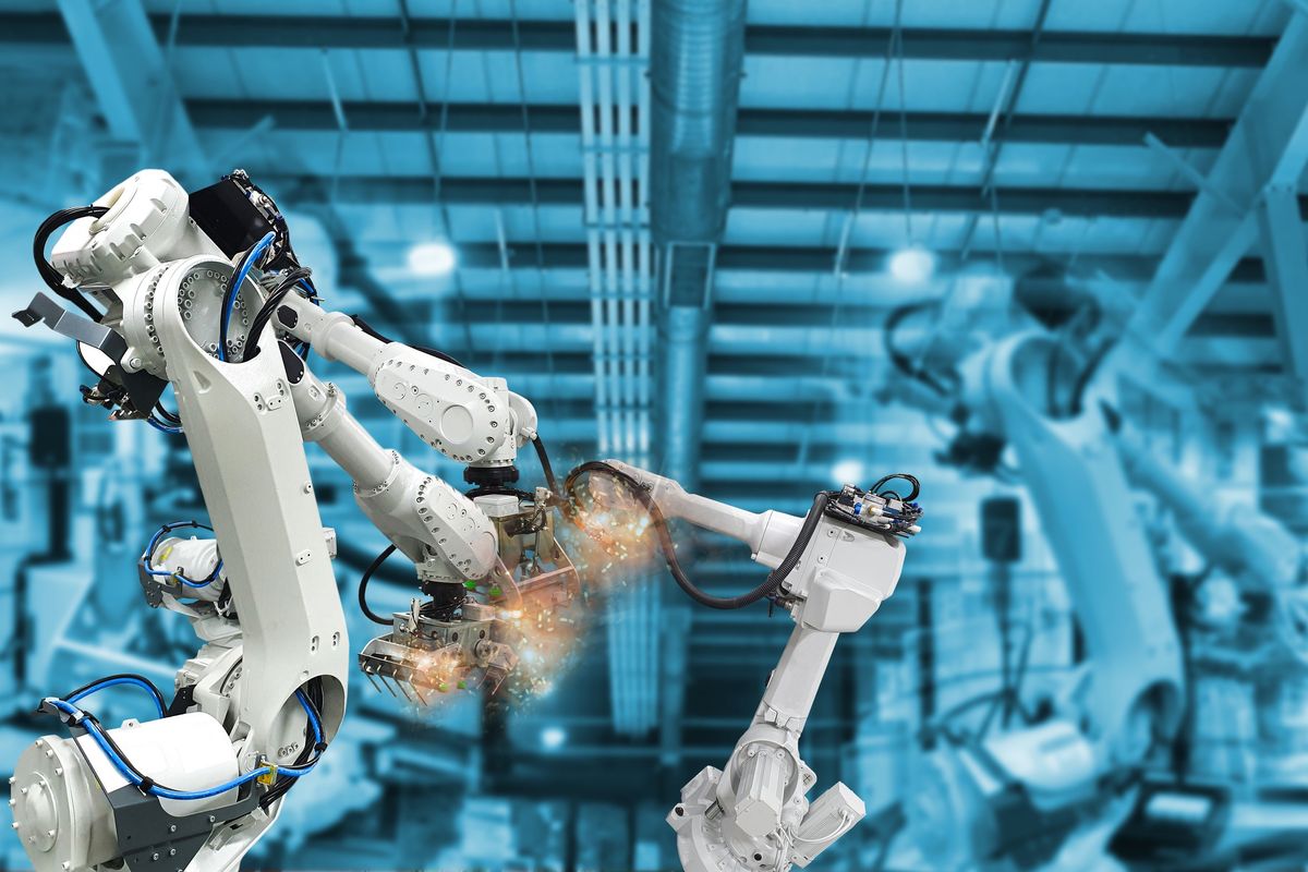 Two industrial robot arms working together in a factory.